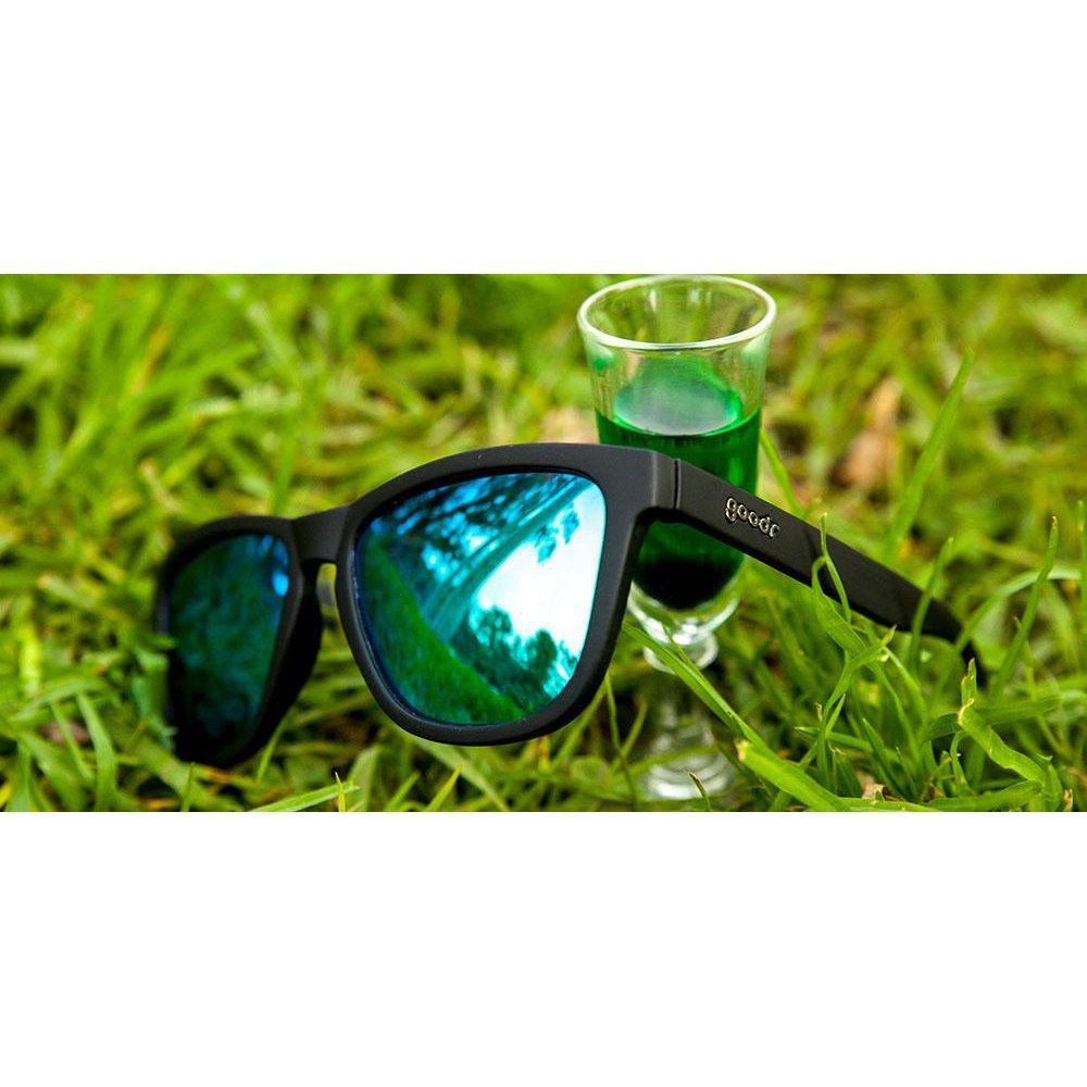 Luxury black polarized sunglasses with reflective blue lenses resting on grass beside a glass shot cup, elegant professional . - "Vincent's Absinthe Night Terrors” OG Polarized Sunglasses - Default Title - Rare Air Discs, Shopify Collective